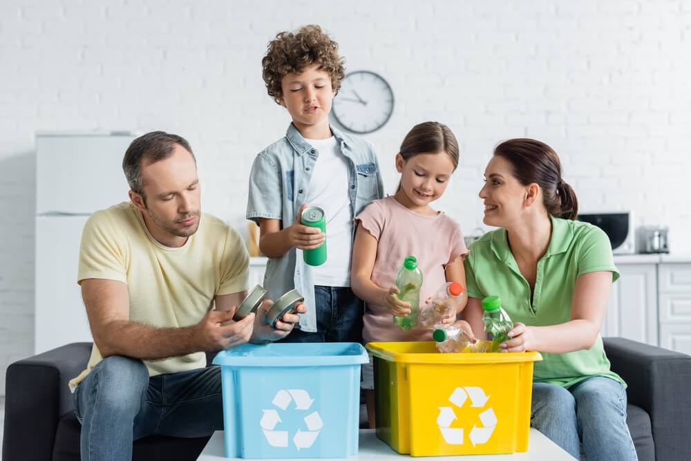 Smiling,Family,Sorting,Trash,Together,In,Boxes,With,Recycle,Symbol