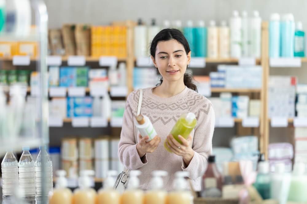 Woman,In,Sweater,Choosing,Herbal,Shampoo,For,Hair,Treatment,At
