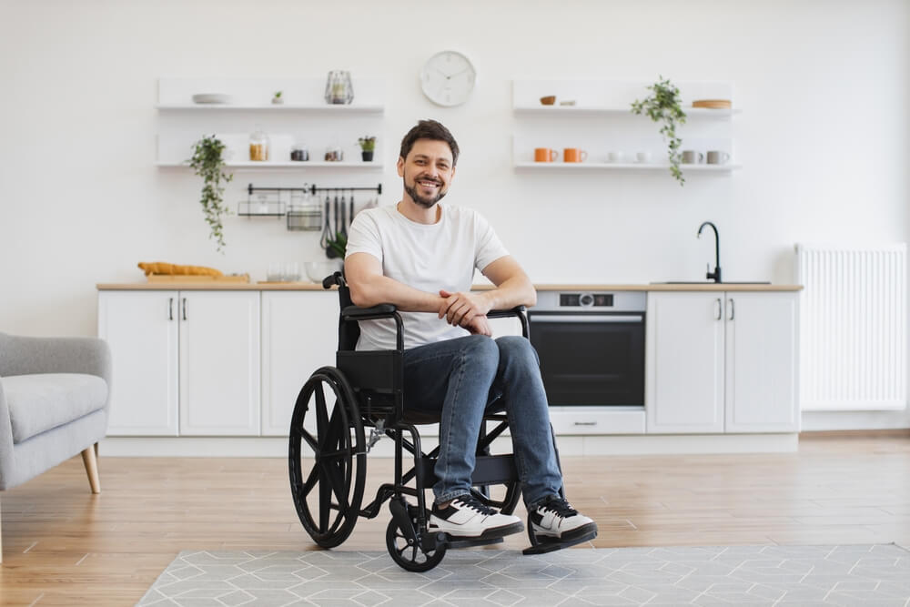 Full,Length,Portrait,Of,Caucasian,Wheelchair,User,Smiling,At,Camera